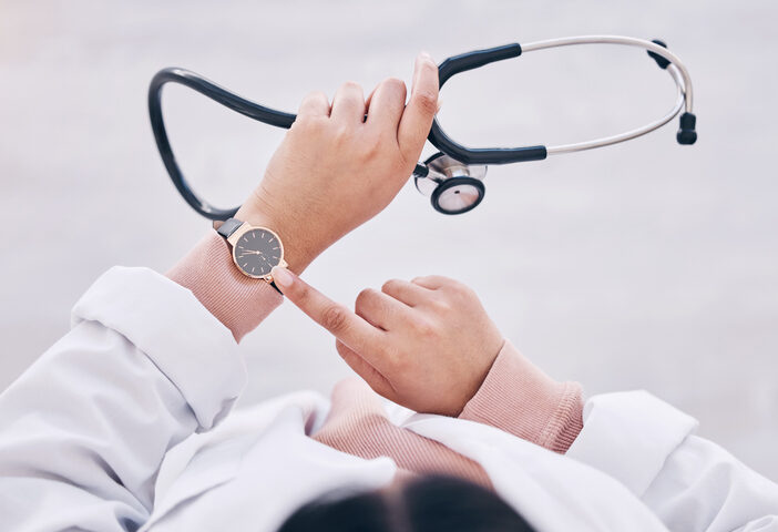 Top view, hands or doctor checking watch in hospital schedule, late appointment or medical biometrics. Woman, stethoscope or clock time in healthcare wellness visit, annual consulting or clinic visit