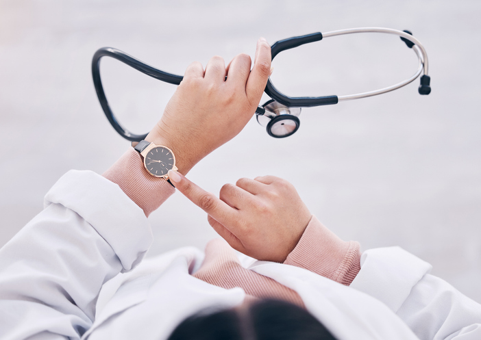 Top view, hands or doctor checking watch in hospital schedule, late appointment or medical biometrics. Woman, stethoscope or clock time in healthcare wellness visit, annual consulting or clinic visit