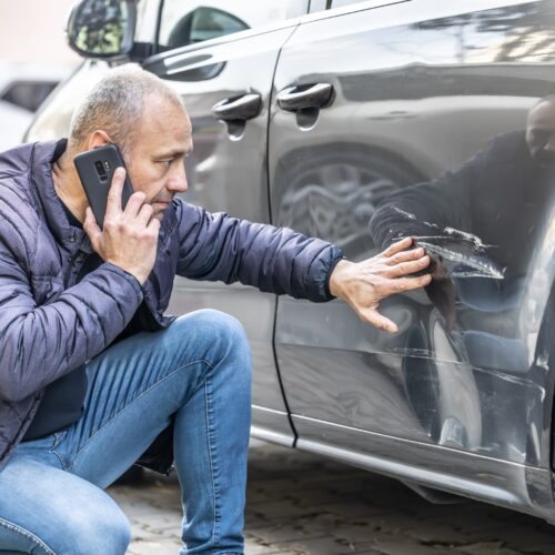 a man calling police after a car collision