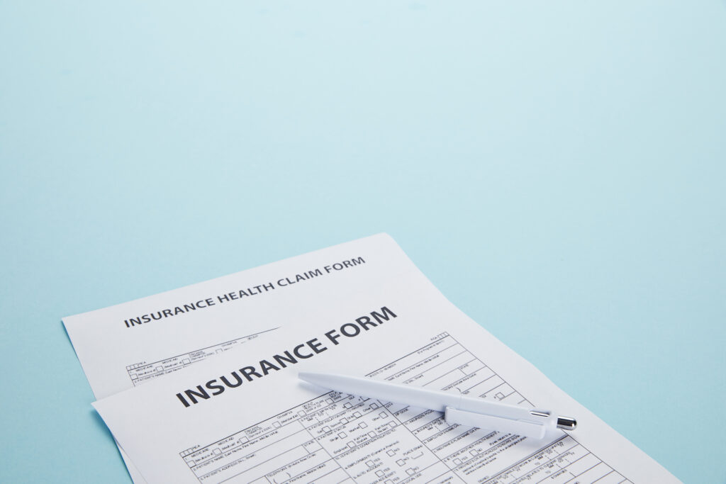 close-up view of insurance form, Bike Accident Claim form and pen isolated on blue