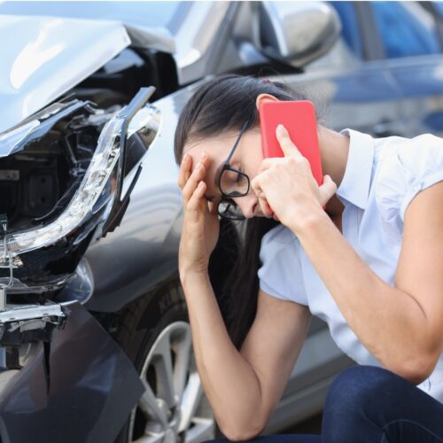 woman on the phone with her own insurance company after being hit by an uninsured driver